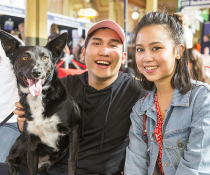 happy couple with black dog at dog lovers show